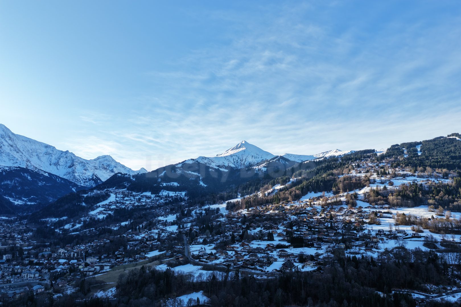 Liberty Drone 5 Vue aérienne panoramique du sommet du Mont-Blanc enneigé, capturée par drone au-dessus de la vallée de Chamonix et de Saint-Gervais-les-Bains sous un ciel bleu.