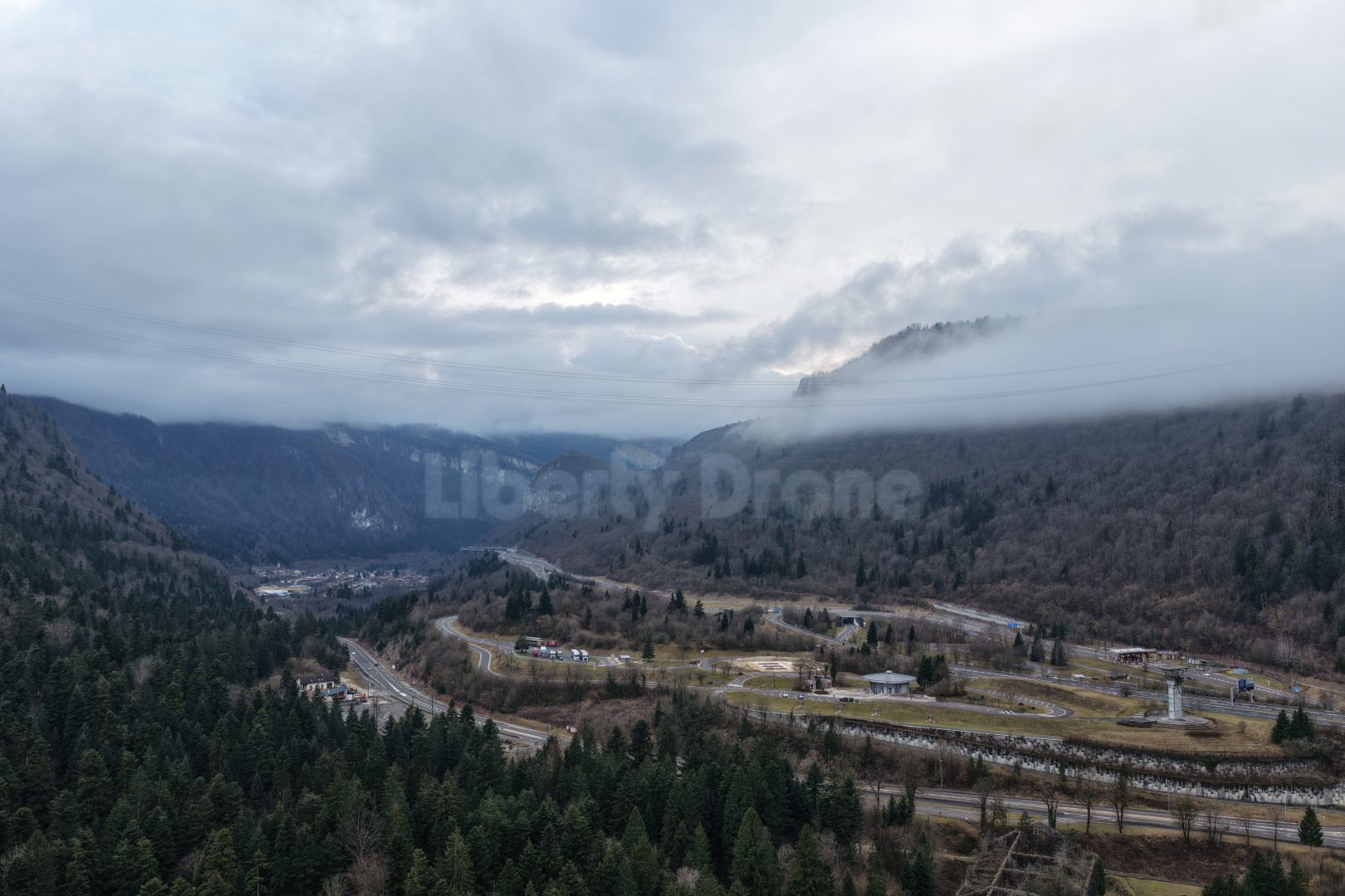 Liberty Drone 10 Vue panoramique des eaux émeraude du Lac de Sylans bordé par les falaises du Jura, situé dans l'Ain sur la route vers la frontière suisse.
