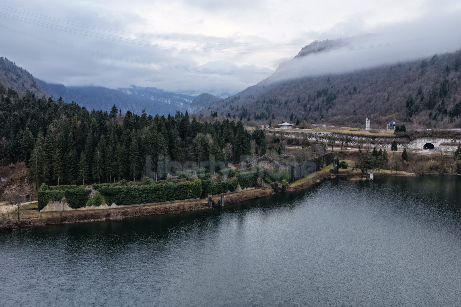 Liberty Drone 11 Vue panoramique des eaux émeraude du Lac de Sylans bordé par les falaises du Jura, situé dans l'Ain sur la route vers la frontière suisse.