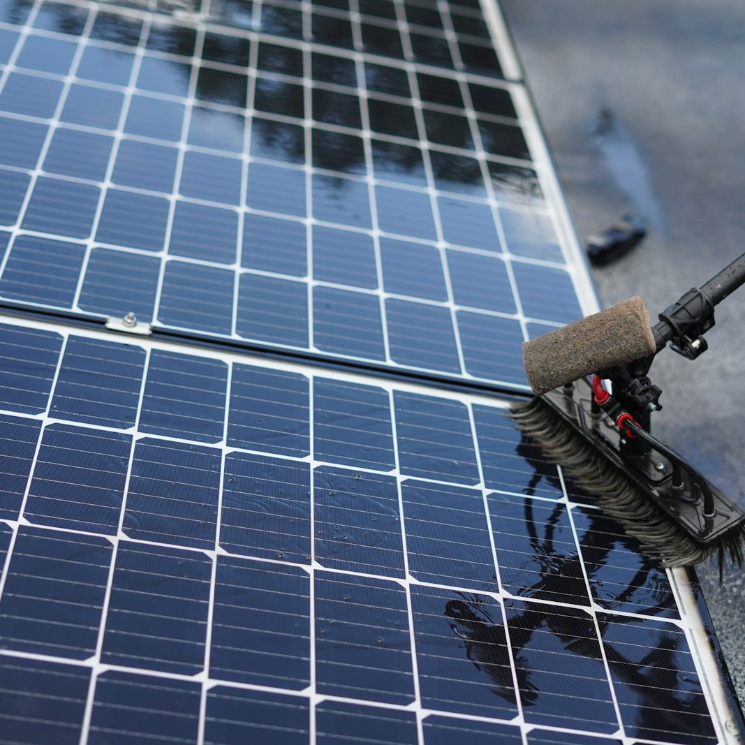 Nettoyage par drone ou perche de panneaux solaires sur un bâtiment